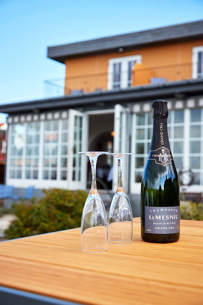 Champagne og glas på bord på terrassen på Kysten Restaurant Bornholm