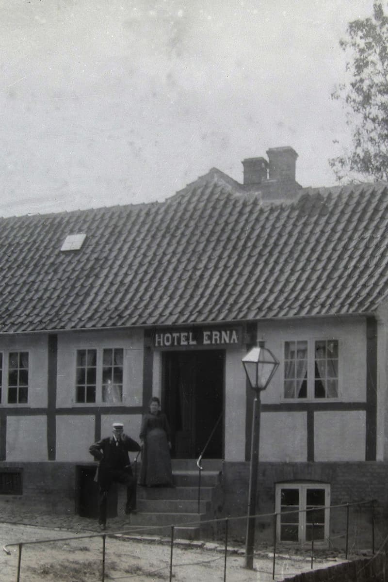 Det tidligere Erna Hotel Bornholm udefra med værtspar på trappen foran indgangen