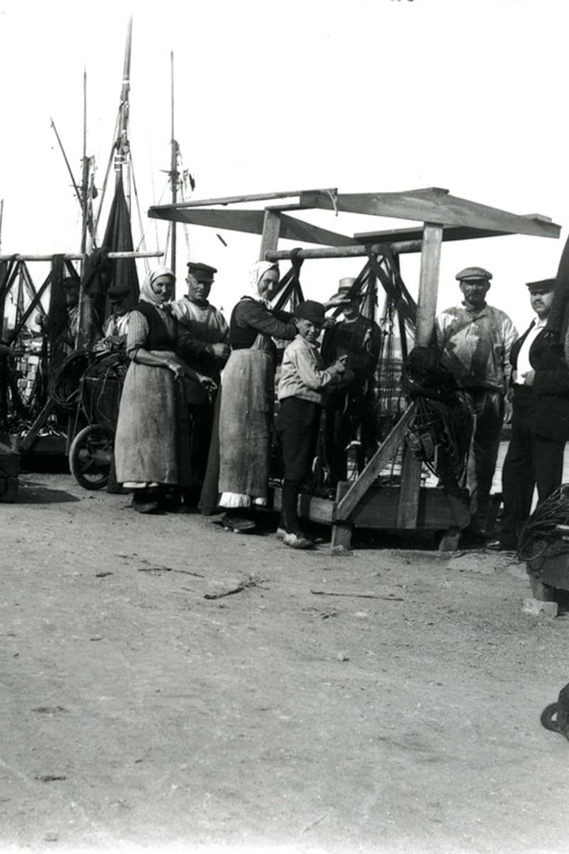Fiskere og deres koner og børn ordner garn på havnen i Hasle